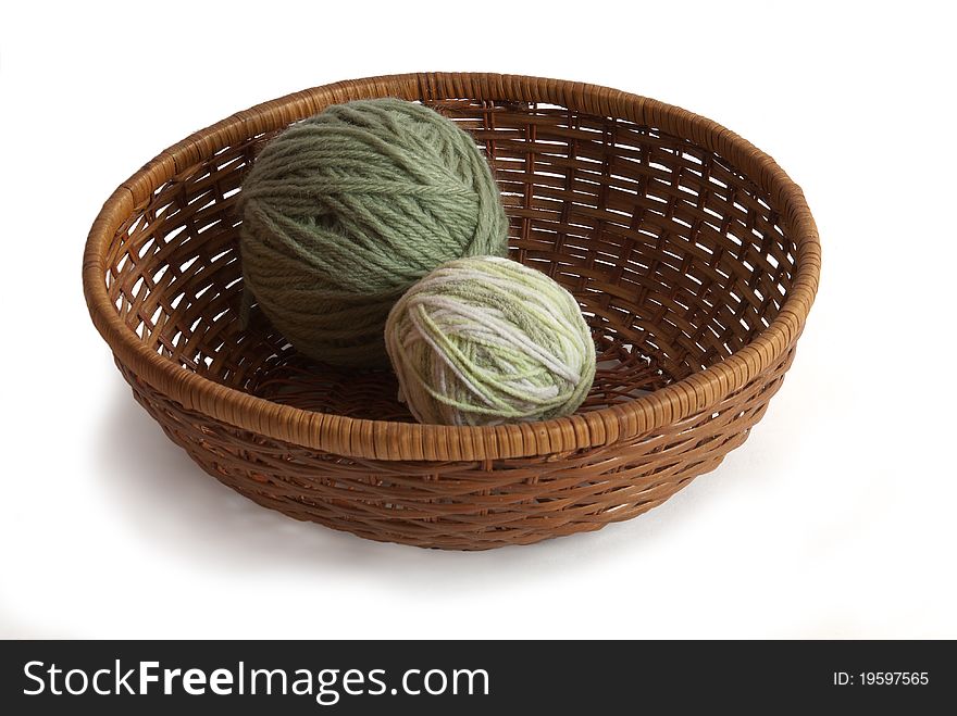 Wattled bowl with balls of threads on a white background