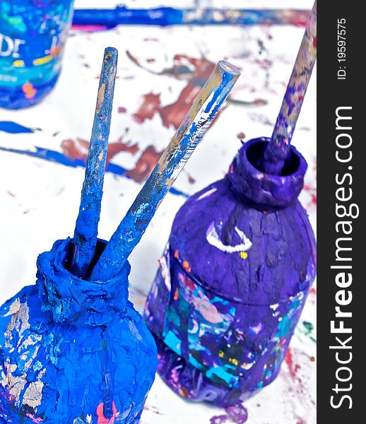 Blue and purple paint in the water bottles with brushes. Blue and purple paint in the water bottles with brushes