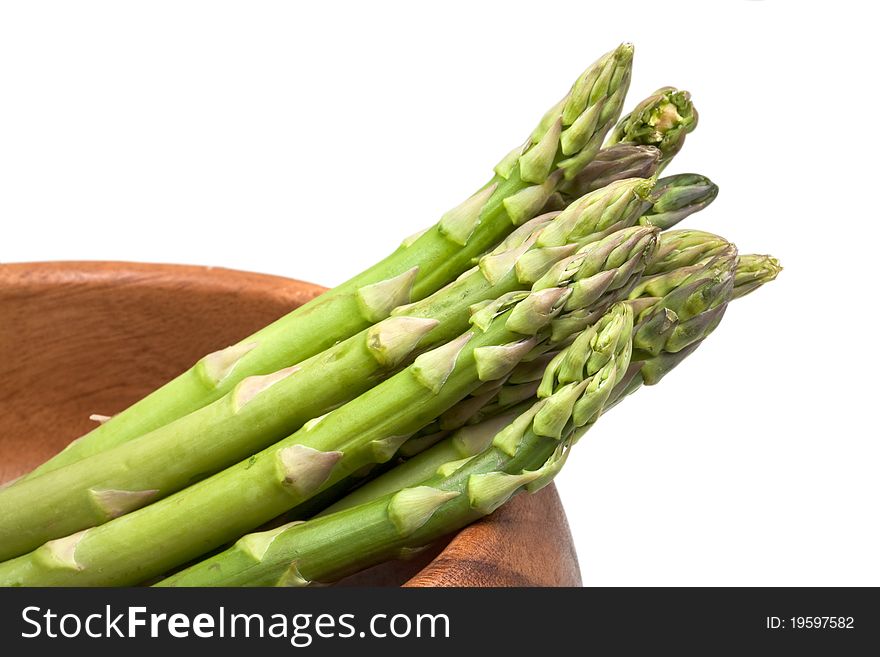 Fresh green asparagus in wooden bowl