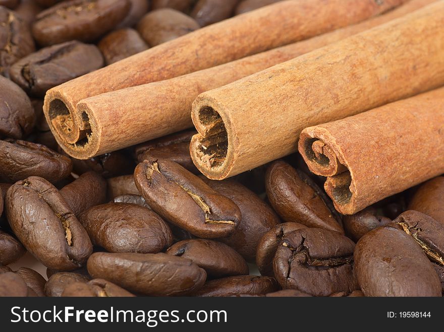 Close-up shot: cinnamon sticks over the coffee beans