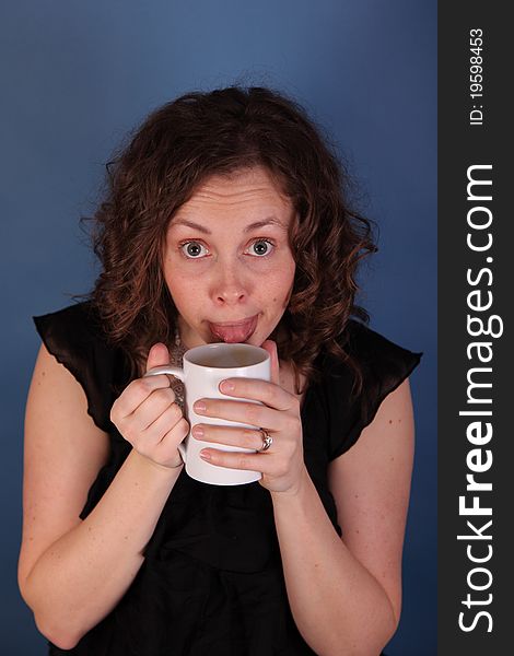 Young woman tests coffee with tongue. Young woman tests coffee with tongue.