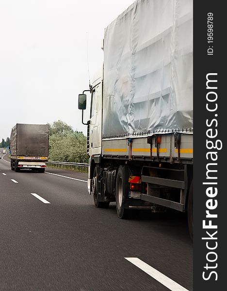 Trucks traveling on highway delivering goods. Trucks traveling on highway delivering goods