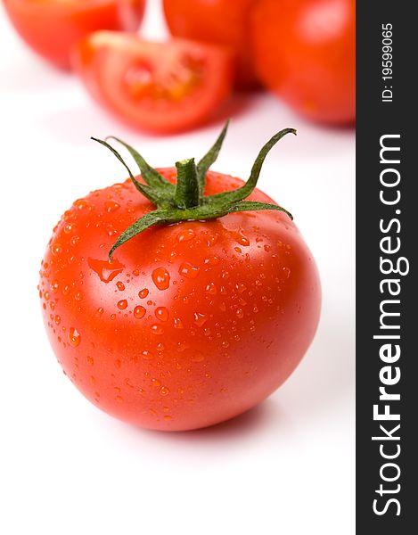 Tomato with water drops close-up on the white.