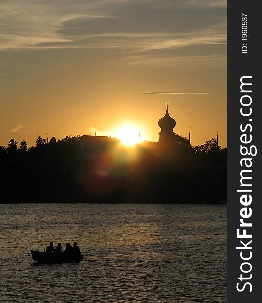 View of people in the boat at the  background silhouette of the city.(Pskov, Russia). View of people in the boat at the  background silhouette of the city.(Pskov, Russia).