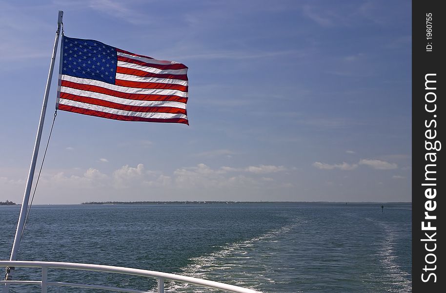 The wake of a speedboat and the north end of Captiva Island - the American Flag waves off the back of the boat. The wake of a speedboat and the north end of Captiva Island - the American Flag waves off the back of the boat