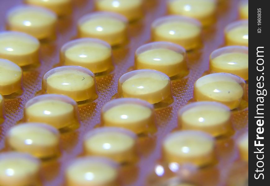 Macro of several yellow pills. Macro of several yellow pills