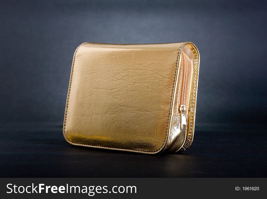 Gold purse in black background.