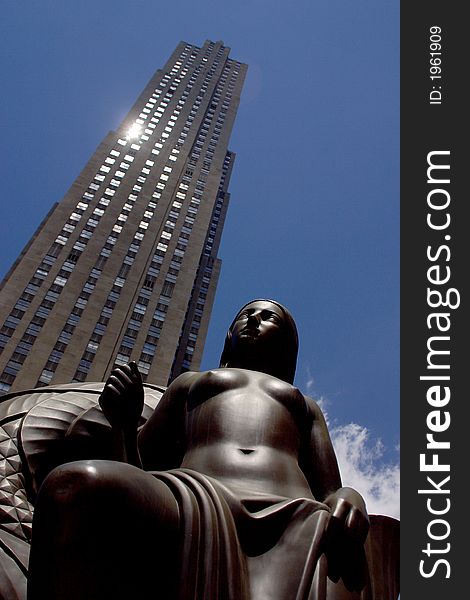 Partial view of a skyscraper with a monument infront in New York City by day, United States, America. Partial view of a skyscraper with a monument infront in New York City by day, United States, America