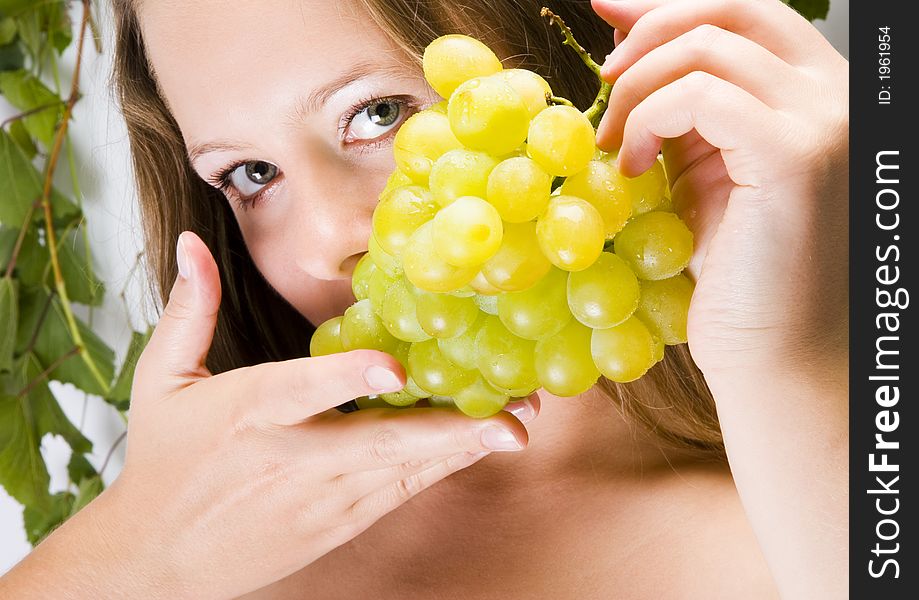 Beautiful young woman portrait with green grape