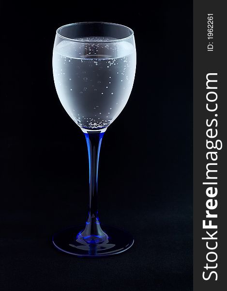 Glass with mineral water on black