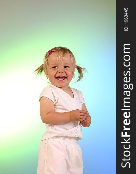 A studio shot of 2 years old little girl dressed white. Background colored by lights. A studio shot of 2 years old little girl dressed white. Background colored by lights