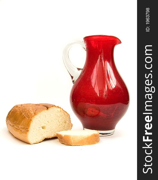 Bread and red jug on white. Bread and red jug on white