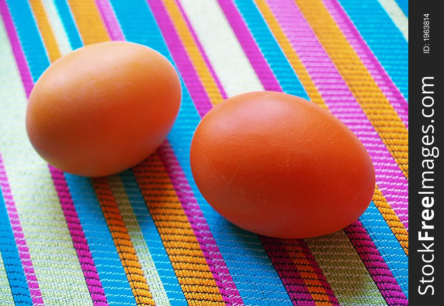 Two easter eggs on the striped fabric. Two easter eggs on the striped fabric