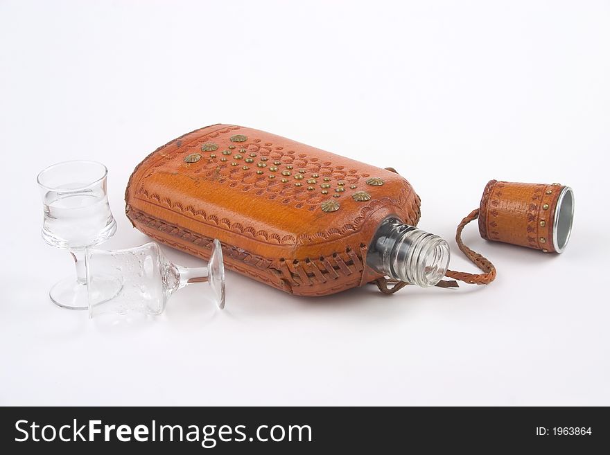 Empty hip flask in horizontal position and with one empty glass. Empty hip flask in horizontal position and with one empty glass