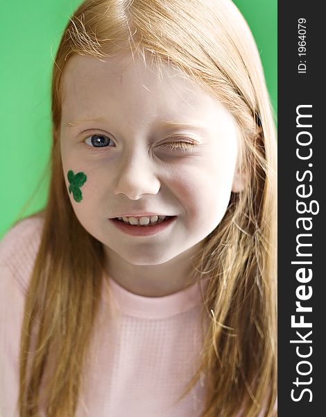 Small redhead girl winking. Shamrock painted on her face for St. Patrick's Day. Small redhead girl winking. Shamrock painted on her face for St. Patrick's Day.