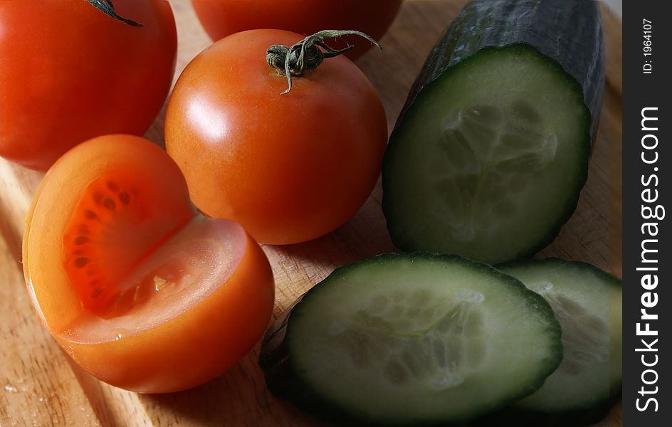 Fresh tasty tomatoes and cucumber on wooden board. Fresh tasty tomatoes and cucumber on wooden board