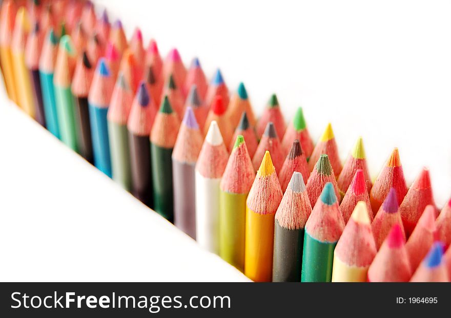 Rainbow of colored pencils in rows on a white background