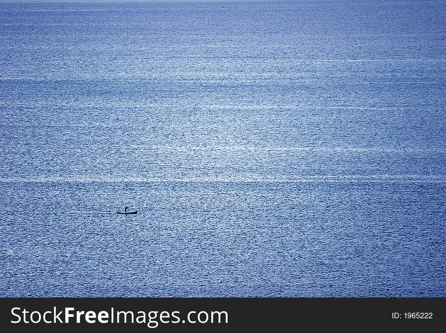 Blue ocean and one canoe in the right side in the corner. Blue ocean and one canoe in the right side in the corner