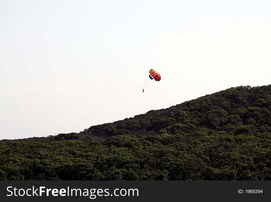 Colourful Parachute, Parasailing, Paragliding, Outdoor Sport Over A Hill With Green Trees