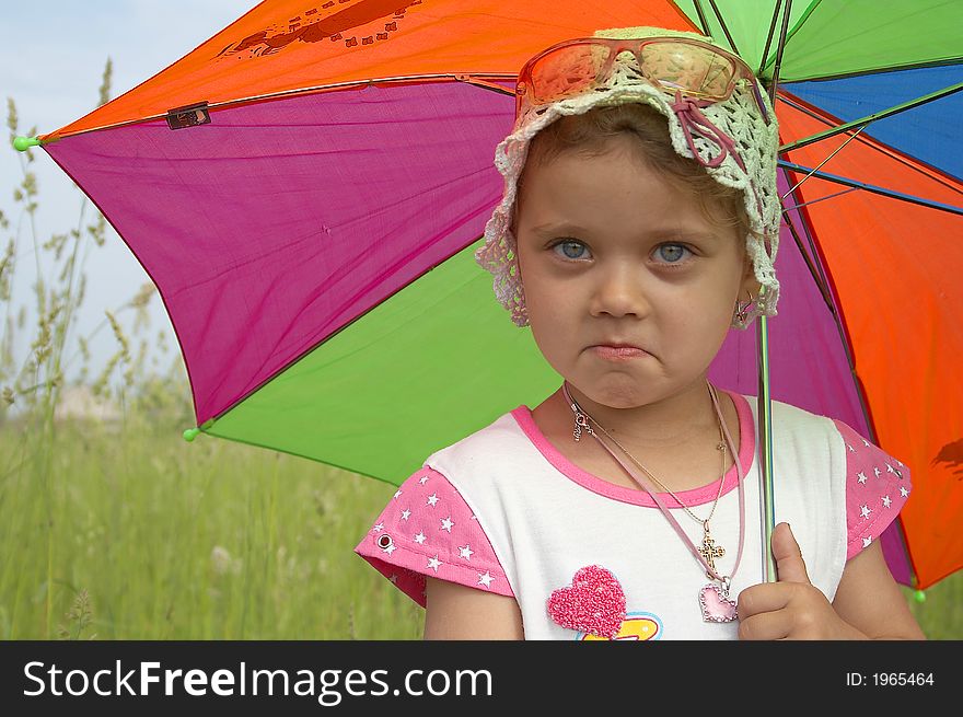 Pretty smiling child with umbrella and white hat