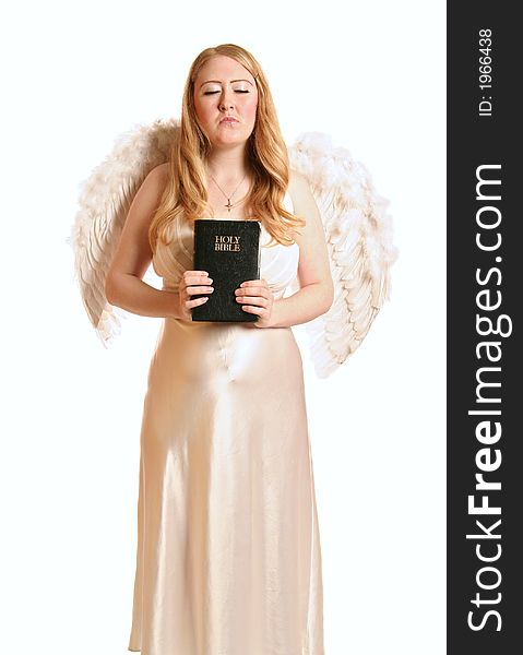 Isolated goddess angel with wing holding a bible and closing her eye. Isolated goddess angel with wing holding a bible and closing her eye