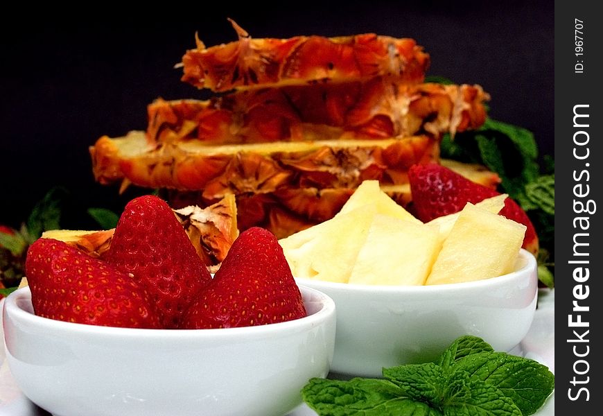 Fruit plate with strawberries and pineapple on black background. Fruit plate with strawberries and pineapple on black background