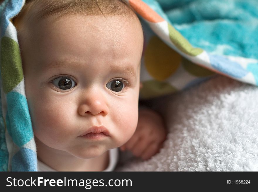 Image of baby peeking out from under a blanket. Image of baby peeking out from under a blanket