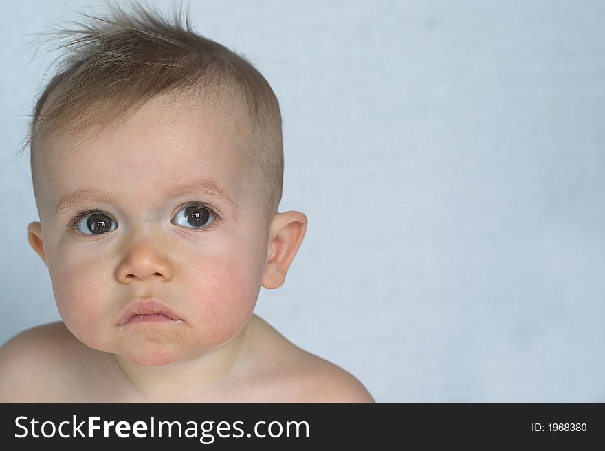 Image of of beautiful baby sitting in front of a white background