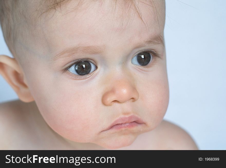 Image of of beautiful baby sitting in front of a white background