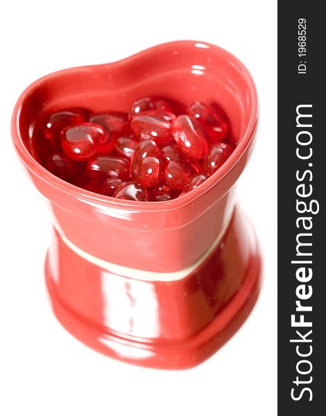 A red heart dish filled with miniature hearts