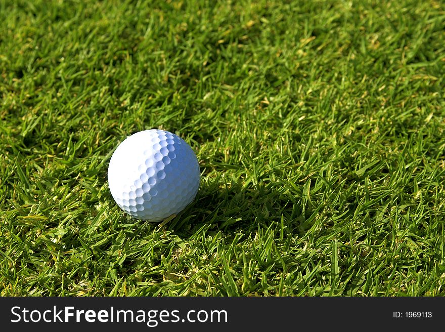 Single golf ball lying on green grass on fairway. Single golf ball lying on green grass on fairway.