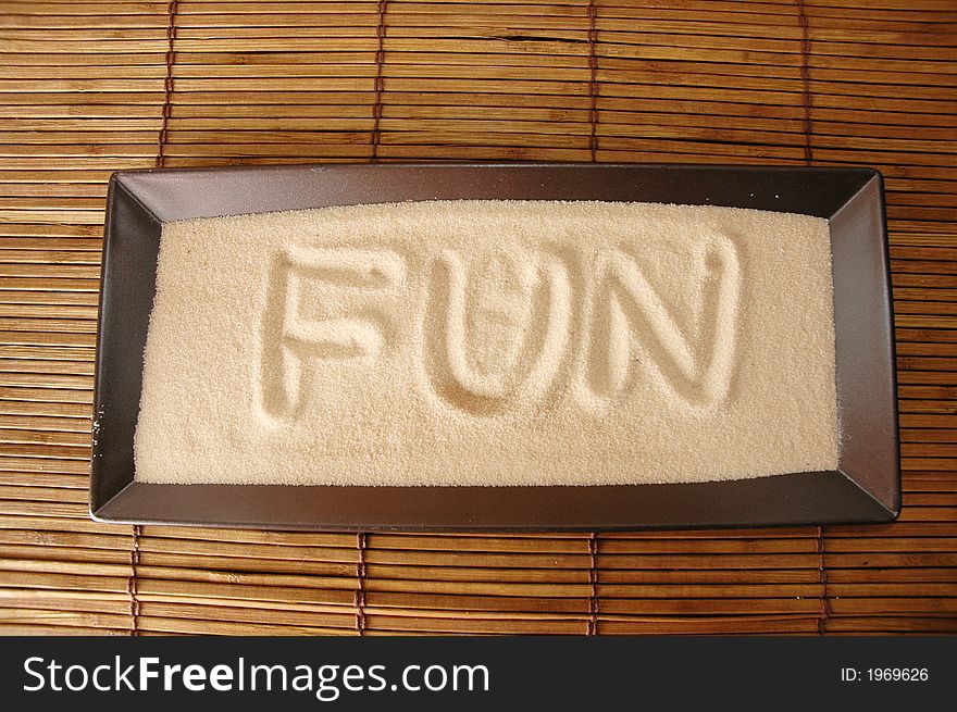Fun is written on sand against bamboo background. Fun is written on sand against bamboo background