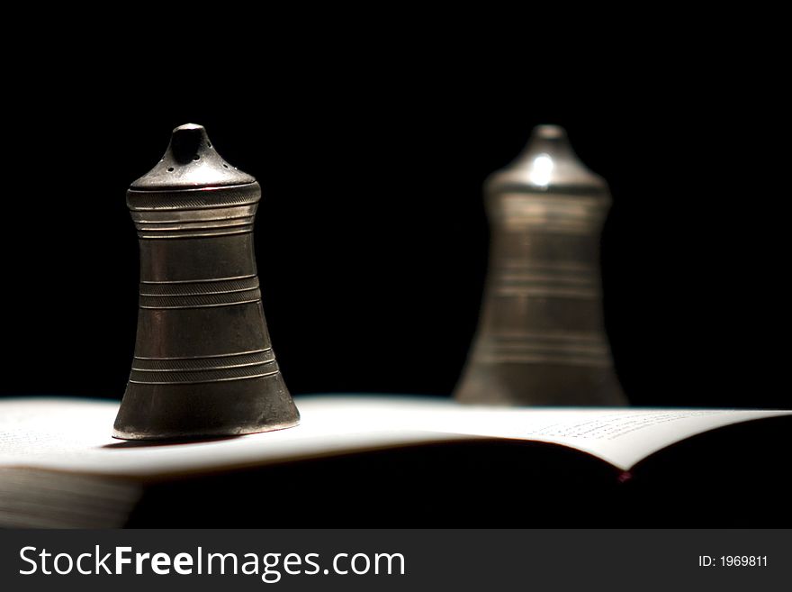 Couple of bells standing on the opened book of Hamlet by Shakespear. Couple of bells standing on the opened book of Hamlet by Shakespear