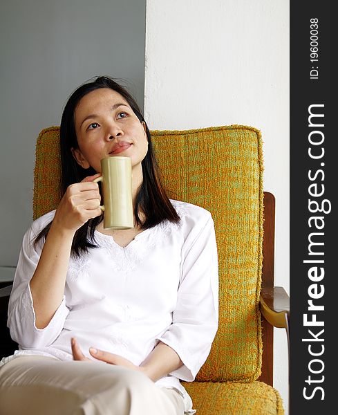 Young Woman Drinking At Cafe