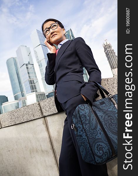 Businesswoman talking the phone, skyscraper background. Businesswoman talking the phone, skyscraper background