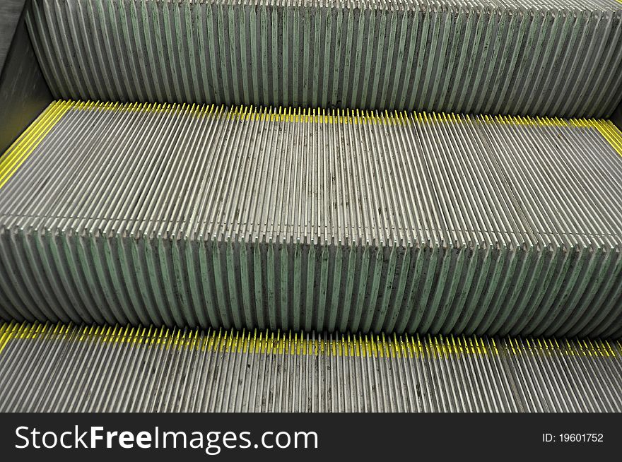 Steps on a escalator with yellow markings on the edges. Steps on a escalator with yellow markings on the edges