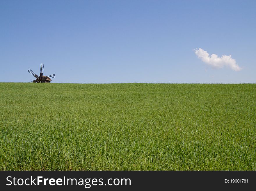 The mill in the field with green grass