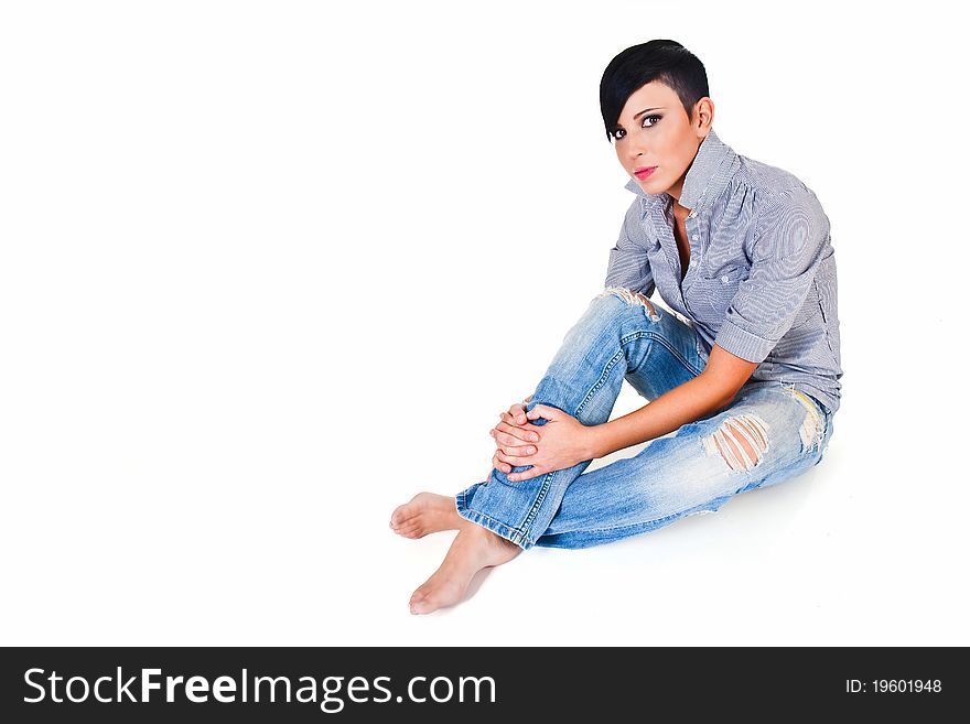 Beautiful short haired young Caucasian woman in blue jeans, over white background
