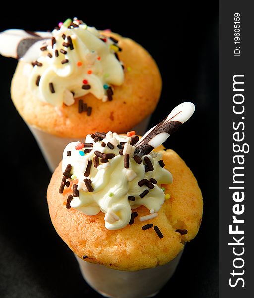 Butter muffins topping with mousse an chocolates ships isolated