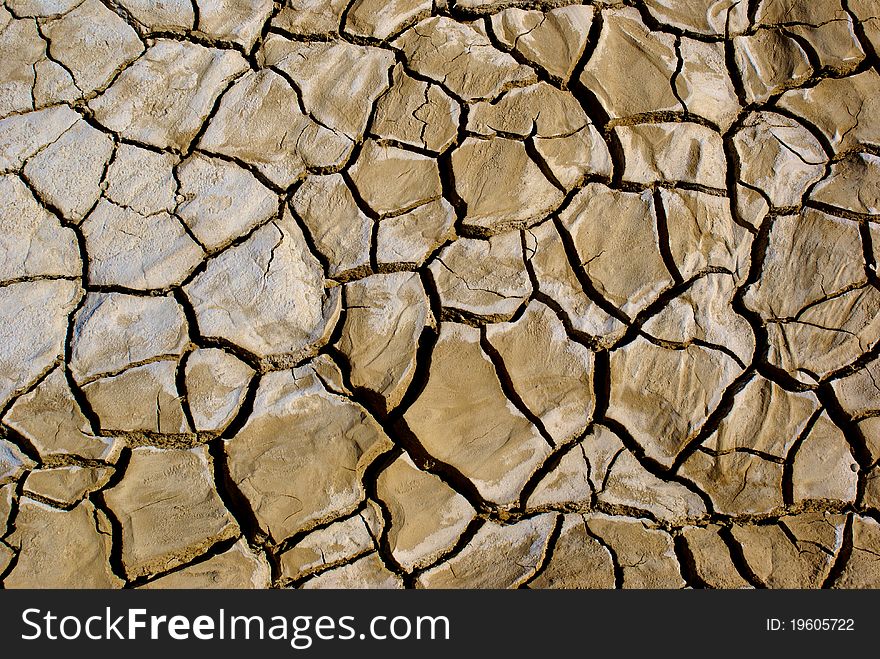 The ground of a California desert flat is cracked from the parching sun. The ground of a California desert flat is cracked from the parching sun.