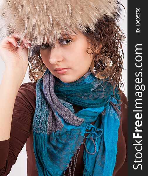 Portrait of a pretty girl in a fur hat isolated on white background