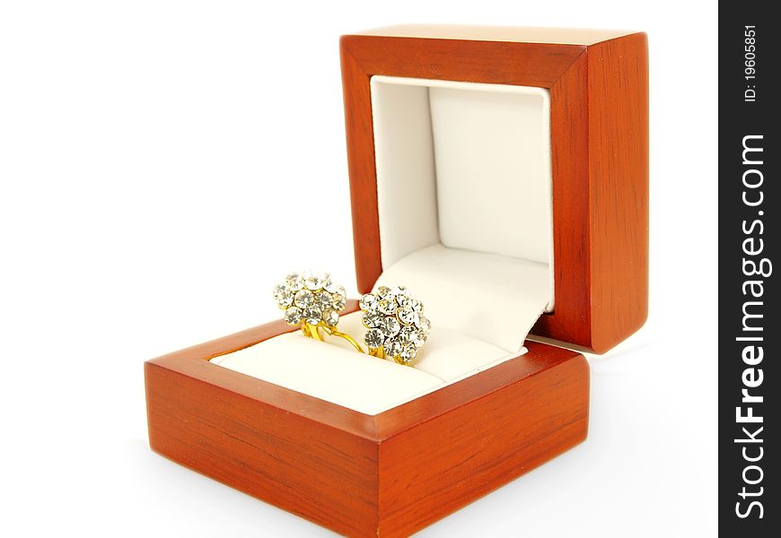 Diamond earrings and yellow gold, isolated towards white background, in a wooden gift box towards white background