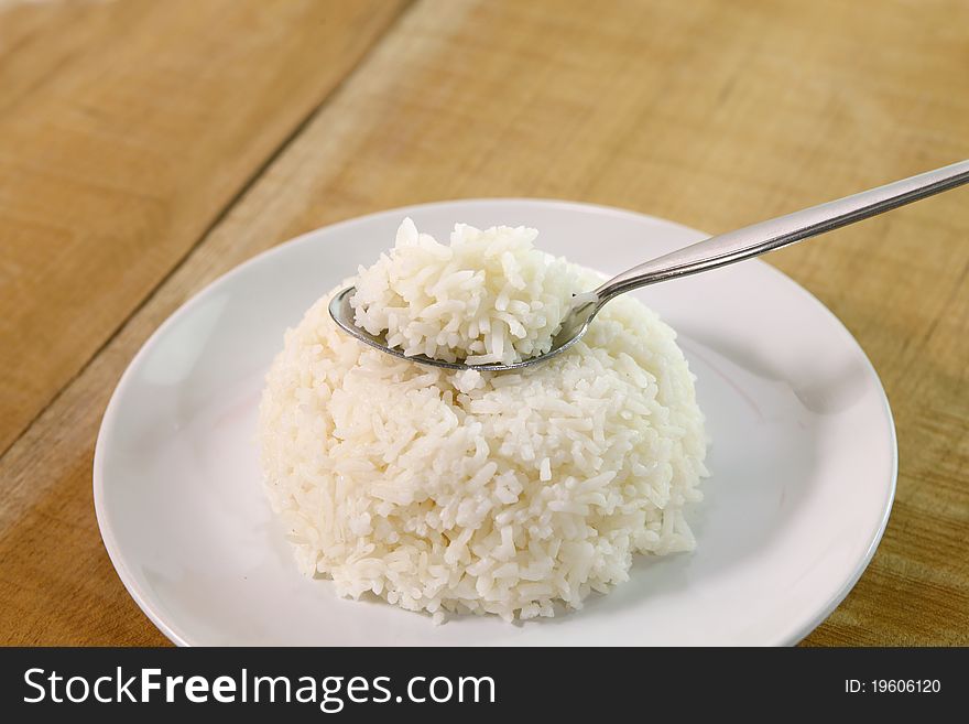 Rice in spoon  on table