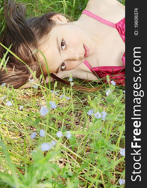 The portrait of beautiful young lady on the grass