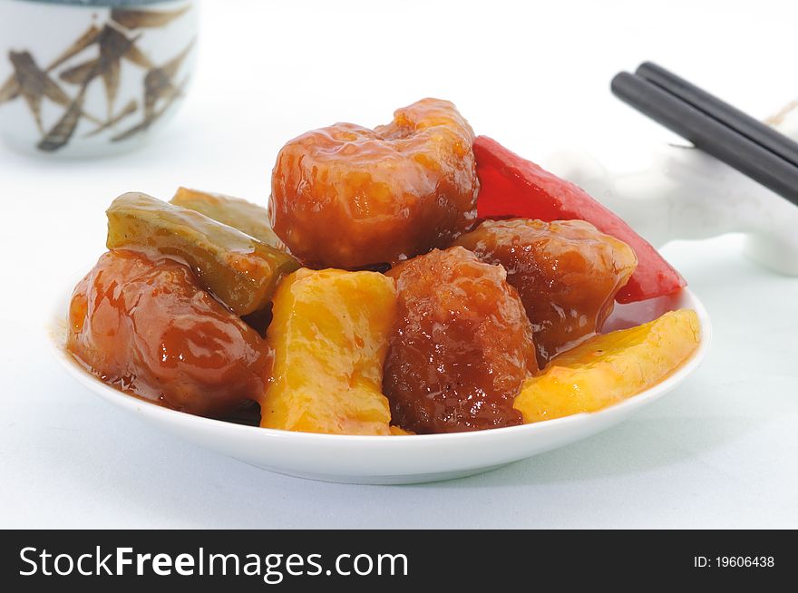 A cantonese dish of sweet and sour pork with peppers and pineapple. A cantonese dish of sweet and sour pork with peppers and pineapple.