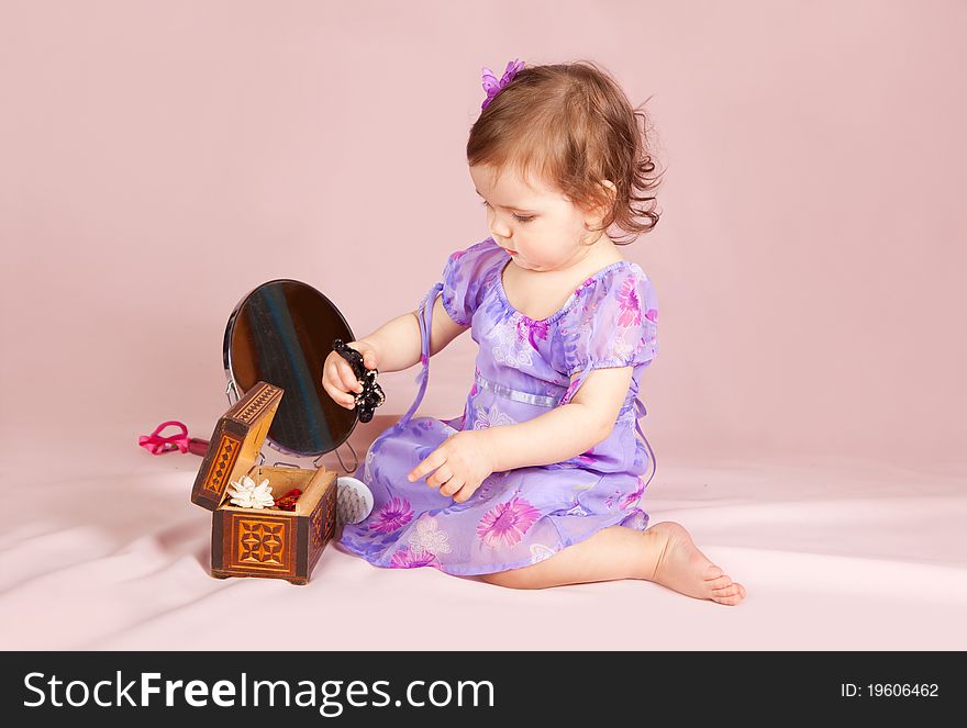 Cute little girl playing with her toys in the studio