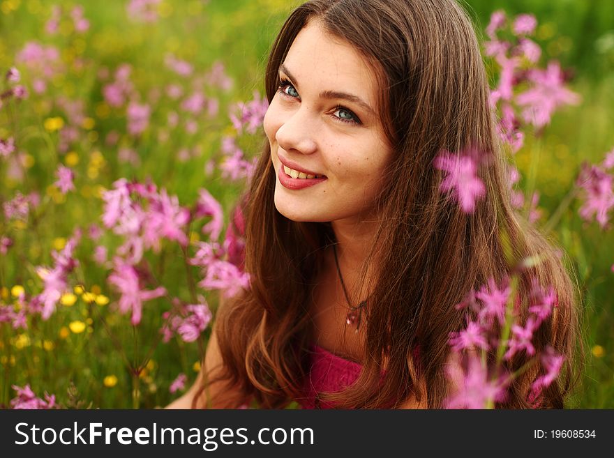 Woman on pink flower field close portrait