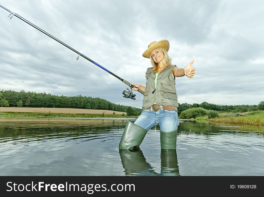 Standing woman fishing in pond. Standing woman fishing in pond