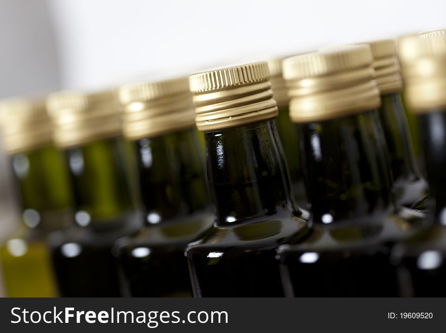 Close up of metal screw caps on dark glass (wine) bottles lined up, on white background. Close up of metal screw caps on dark glass (wine) bottles lined up, on white background.