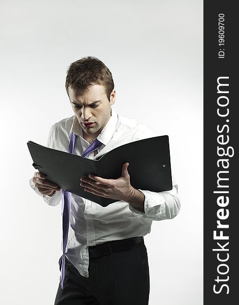 Businessman in financial ruin looking at a file with desperate expression. Businessman in financial ruin looking at a file with desperate expression